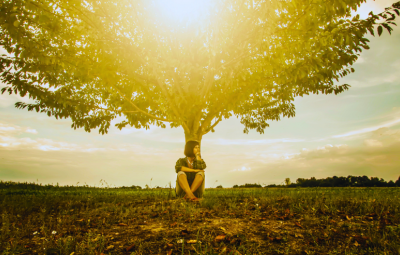 girl sits under a tree