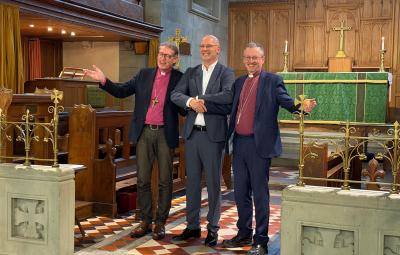 2 bishops and a man in front of an altar