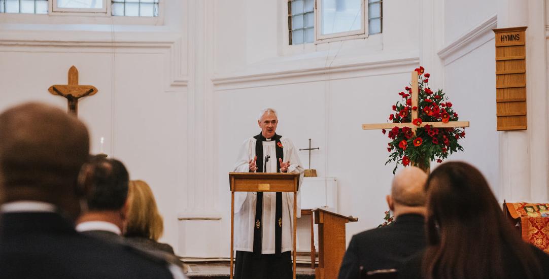 vicar standing at the front of the congregation