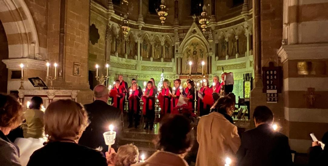 people in service holding candles