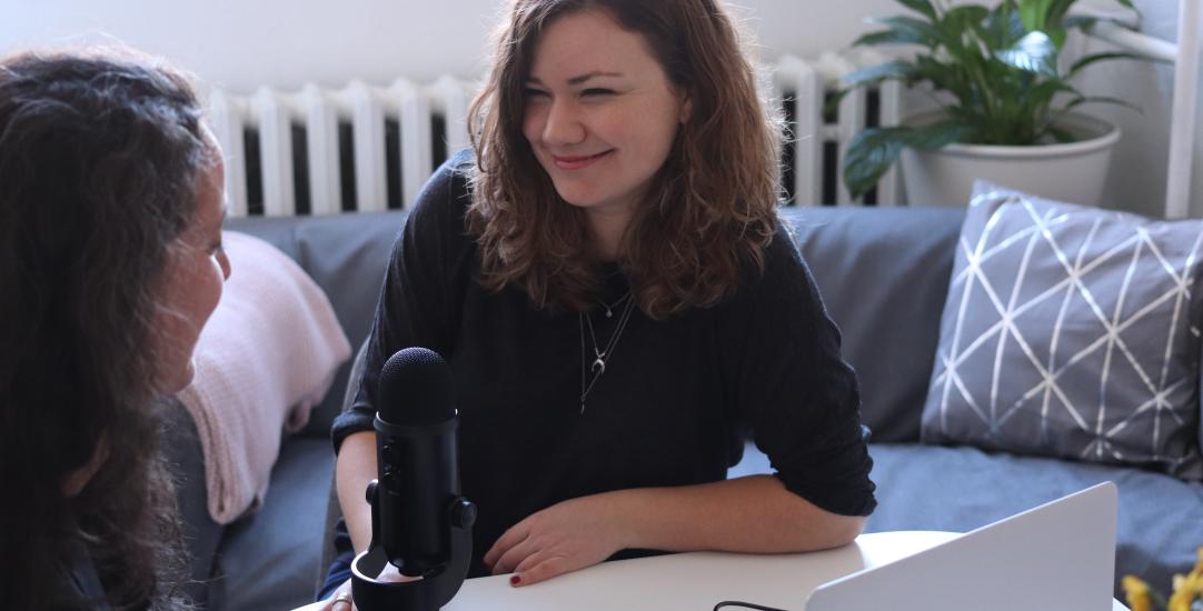 two women talking into a microphone 