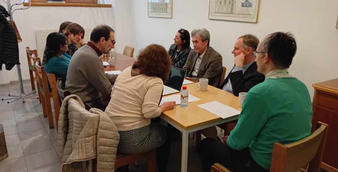 A group of people sit round a table