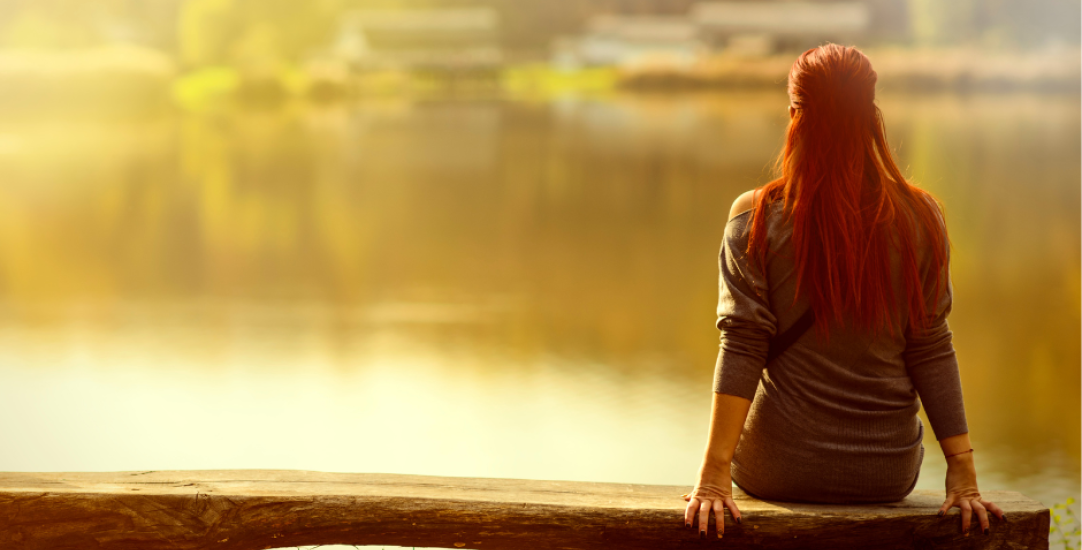 Person from behind looking at a lake