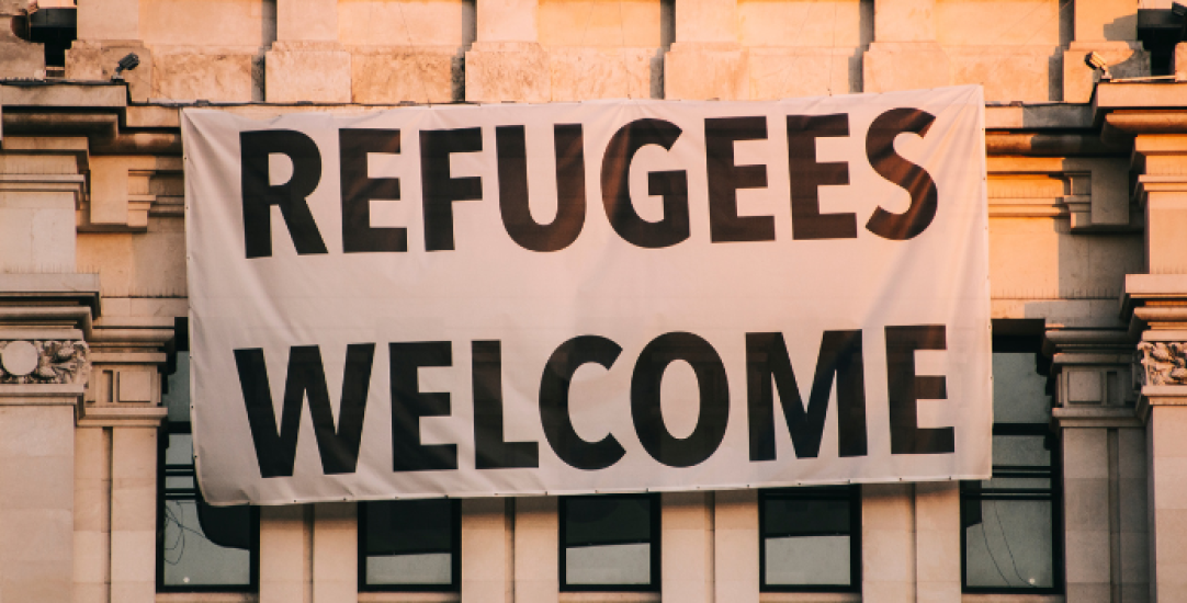 a sign on a building saying Refugees Welcome