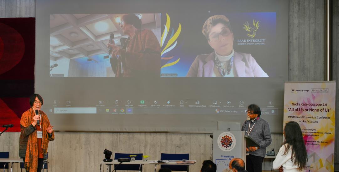 people on ascreen remotely recorded on a conference stage